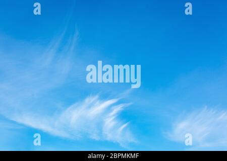 Blue sky with cirrus clouds. Thin, wispy strands of atmospheric clouds. Gentle sky background. Stock Photo