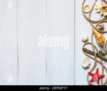 Summer interior decoration with starfishes, seashells, sand, ropes and stones on white wooden background. Copy space. Still life. Flat lay Stock Photo