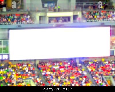 scene of big white led billboard with a lot of fans in the big stadium. -blurred picture.. Stock Photo