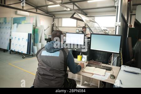 Technician operator engineer analyse status of printing jobs on the central computer in digital printshop office Stock Photo