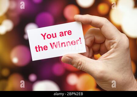 You Are The Winner - an inscription on a card that a person holds on a background of fireworks Stock Photo