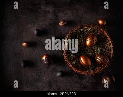 Black and gold eggs over black background. Flat lay Stock Photo