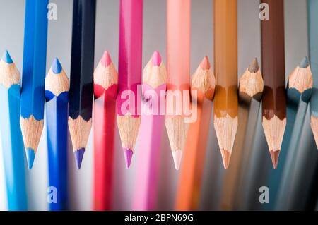 Close-up of juxtaposed colored pencil tips on a neutral gray background. Stock Photo
