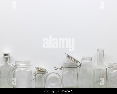 many different empty glass bottles lying on a white background Stock Photo