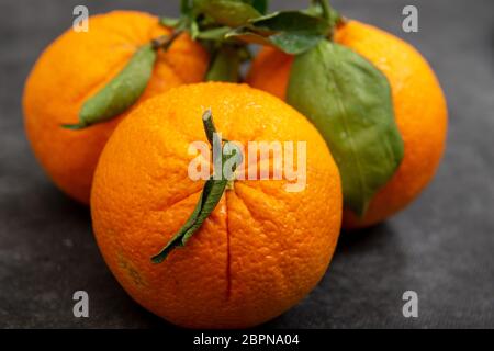 three delicious organic oranges on the black table Stock Photo