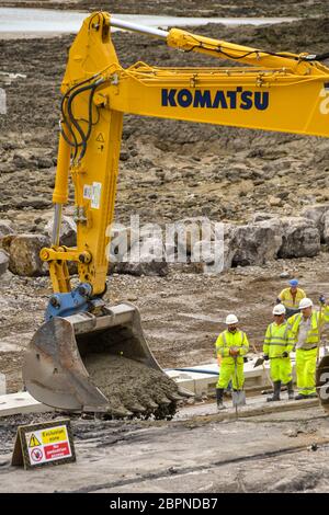 PORTHCAWL, WALES - JUNE 2018: Close up view of construction operatives laying concrete on the seafront in Porthcawl. Stock Photo