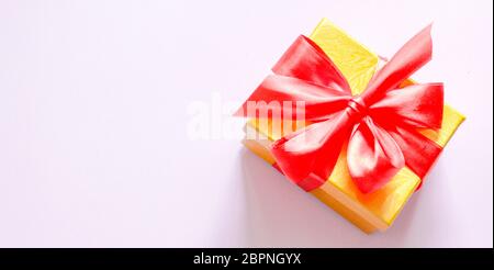 Banner gift box with red bow on a pink background. Flat lay. Top view.  Stock Photo