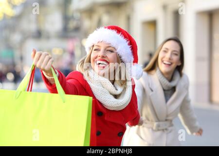 Shoppers shopping and showing bags in christmas outdoor on the street Stock Photo