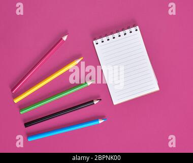 open notebook with empty white sheets and multicolored wooden pencils Stock Photo