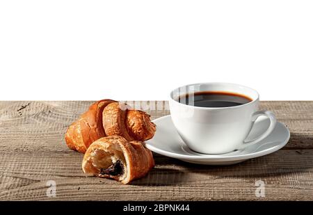 Coffee and croissants on a wooden table. Broken croissant. Isolated on white background. Stock Photo