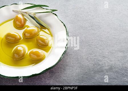 Extra virgin healthy Olive oil with fresh olives in plate close up Stock Photo