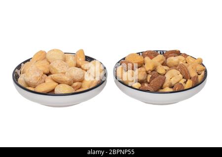 Nuts background. Close-up of roasted and salted macadamias, almonds, cashew nuts in two ceramic bowls isolated on a white background. Gourmet nut mix Stock Photo