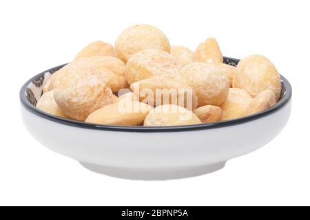 Nuts background. Close-up of roasted and salted macadamias and almonds nuts in ceramic bowl isolated on a white background. Gourmet nut mix with macad Stock Photo