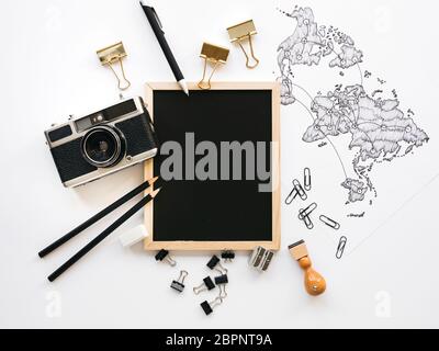 old, vintage camera with black notebook and hand-drawn world map on white background Stock Photo