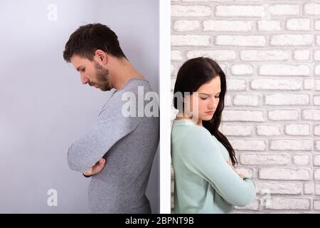 Side View Of Young Unhappy Couple Standing Back To Back At Home Stock Photo