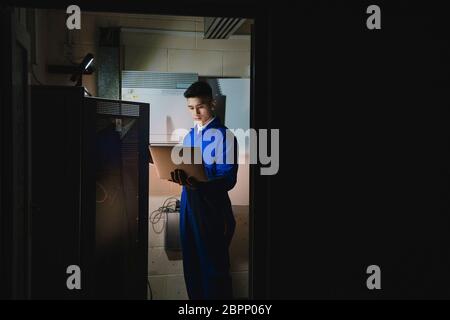 Trainee technician is working in the server room. Stock Photo
