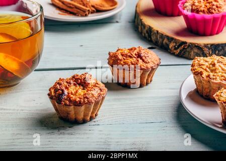 Healthy Dessert. Oatmeal muffins with cup of green tea over light wooden background. Stock Photo