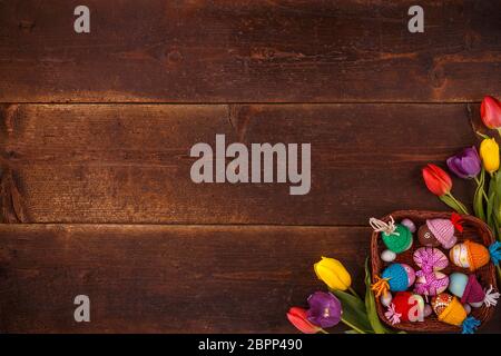 Easter eggs and tulips on old wooden background. View from above with copy space Stock Photo
