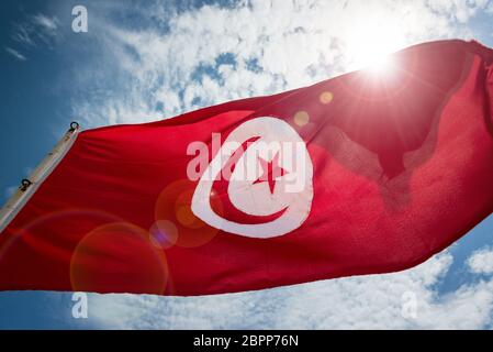 Tunisian flag waving in the wind with lens flare in Monastir, Tunisia Stock Photo