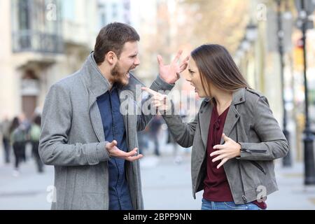 Angry couple arguing in the middle of a city street Stock Photo