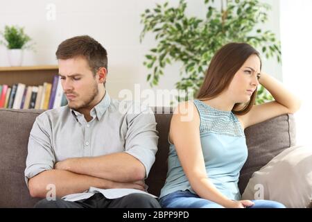 Angry couple ignoring each other after argument sitting on a sofa at home Stock Photo