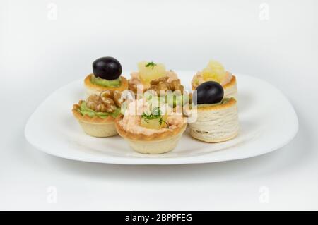 Several beautiful tartlets with different fillings on a white background Stock Photo