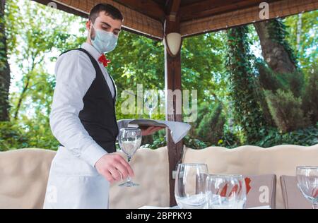 the waiter works in a restaurant on the summer terrace Stock Photo