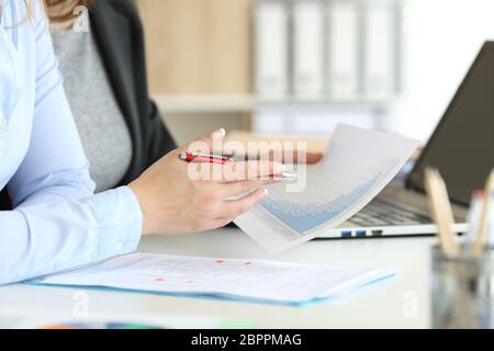 Close up of two office worker hands analyzing a growth graph on a desktop Stock Photo