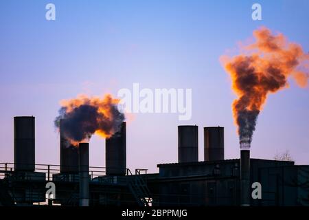 Dark smoke comming from the chimneys of an old factory. Stock Photo