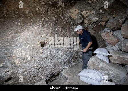 Jerusalem, Israel. 19th May, 2020. An Israeli archaeologist works at an archaeological excavation site in Jerusalem, on May 19, 2020. Israeli archaeologists have discovered a unique 2,000-year-old subterranean system, hewn in the bedrock near the Western Wall Plaza in ancient Jerusalem, the Israel Antiquities Authority (IAA) said on Tuesday. (JINI via Xinhua) Credit: Xinhua/Alamy Live News Stock Photo