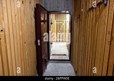 Inside of a bunker with a wooden interior and an open metal door to protect from a bomb attack Stock Photo