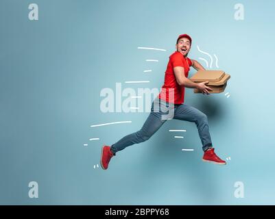 Courier runs fast to deliver quickly pizzas. Cyan background Stock Photo