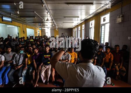 Beirut, Lebanon. 19th May, 2020. Foreign workers from Bangladesh gather in the canteen of their accommodation at RAMCO Waste Management as a representative from the Bangladeshi Embassy talks with them to try and resolve pay disputes following the collapse of the Lebanese pound that led to earlier rioting at the center. Credit: Elizabeth Fitt/Alamy Live News Stock Photo