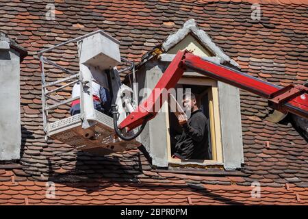 Zagreb, Croatia - April 16, 2020 : Workers with cranes fixing the roofs that was damaged by the earthquake of 5.5 on the Richter scale one month ago.
