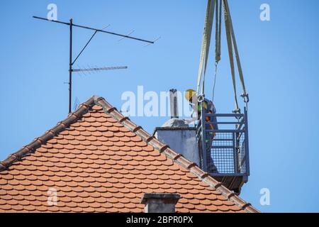 Zagreb, Croatia - April 16, 2020 : Workers with cranes fixing the roofs that was damaged by the earthquake of 5.5 on the Richter scale one month ago.