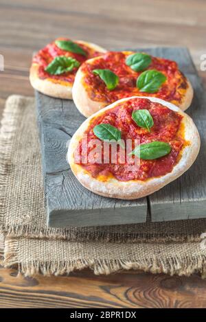 Mini Margherita pizzas with red cheese on the wooden board Stock Photo