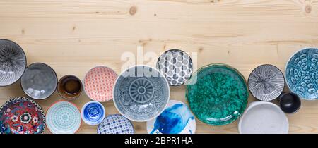 different kinds of modern colourful crockery on light wood background Stock Photo