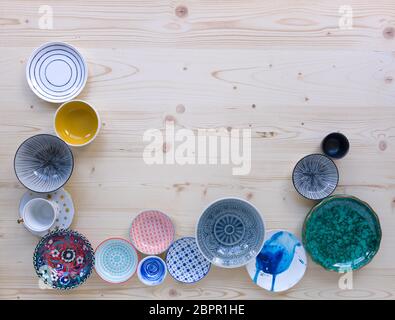 different kinds of modern colourful crockery on light wood background Stock Photo