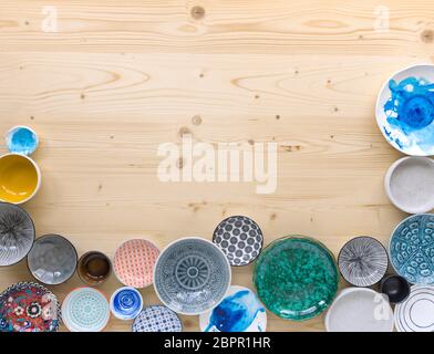 different kinds of modern colourful crockery on light wood background Stock Photo