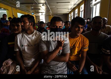 Beirut, Lebanon. 19th May, 2020. Foreign workers from Bangladesh gather in the canteen of their accommodation at RAMCO Waste Management as a representative from the Bangladeshi Embassy talks with them to try and resolve pay disputes following the collapse of the Lebanese pound that led to earlier rioting at the center. Credit: Elizabeth Fitt/Alamy Live News Stock Photo