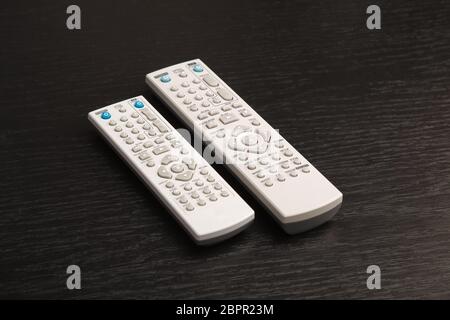 Remote controls on a dark table Stock Photo