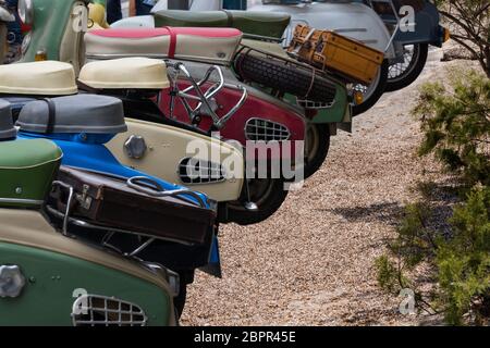 Various retro scooters line the road in a row. Stock Photo