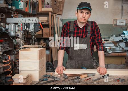 Carpenter working with a chisel and hammer in a wooden workshop Stock Photo