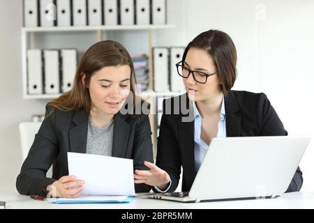 Two executives working together talking about documents at workplace Stock Photo