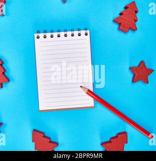 notebook with empty white sheets in line and red wooden pencil, blue background, empty space Stock Photo
