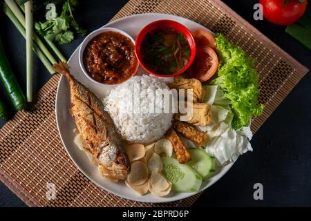 Fried mackerel fish rice with sambal, popular traditional Malay or Indonesian local food. Flat lay top down overhead view. Stock Photo