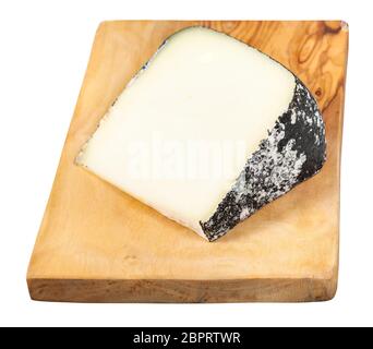 piece of local italian Perla Nera sheep's milk cheese on olive wood cutting board isolated on white background Stock Photo