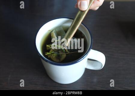 Tea with Green and dired Stevia leaves in white glass Stock Photo