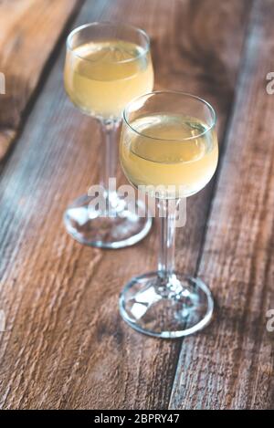 Two glasses of limoncello on the wooden background Stock Photo