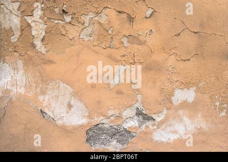Peeling paint on a dilapidated house wall with cracks. It can be used as concepts or backgrounds. Stock Photo